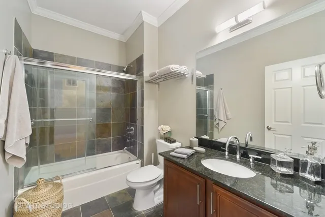 a bathroom with a granite countertop sink toilet mirror and bathtub