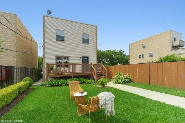 a view of a chair and table in backyard of the house
