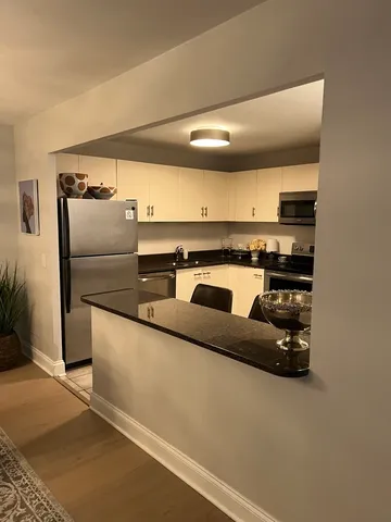 a kitchen with stainless steel appliances granite countertop a refrigerator and a stove