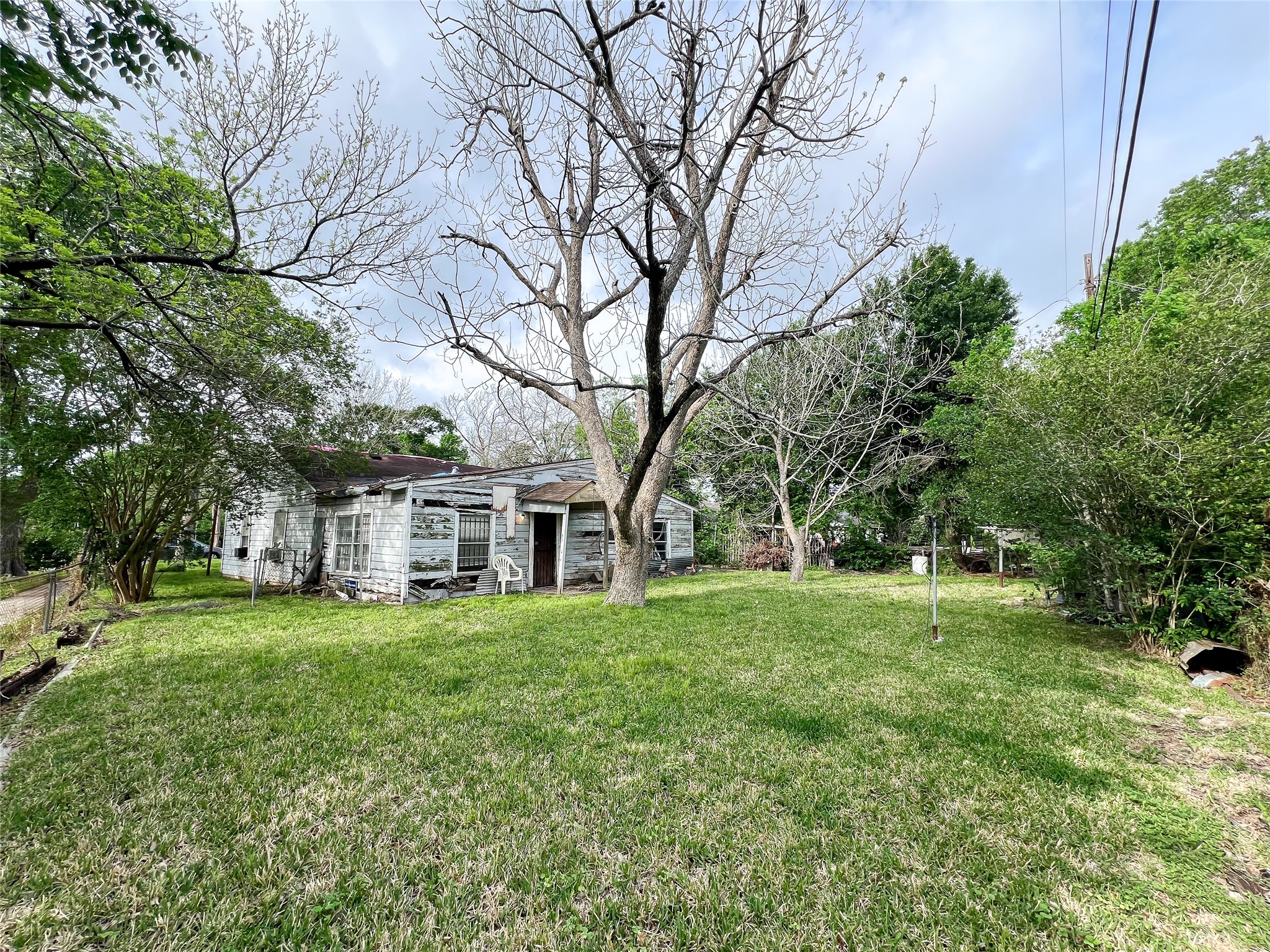 a view of a house with a big yard and large trees
