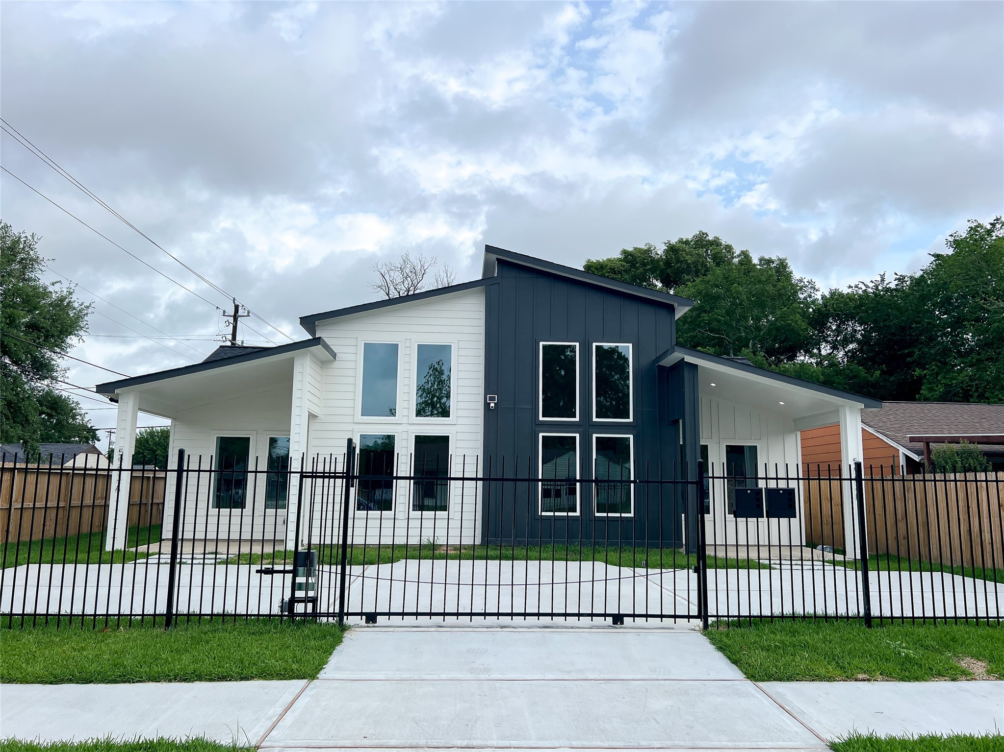 5863 Southgood Street Houston, TX 77033 - Photo 6 of 6 a view of a white house that has a small yard and wooden fence