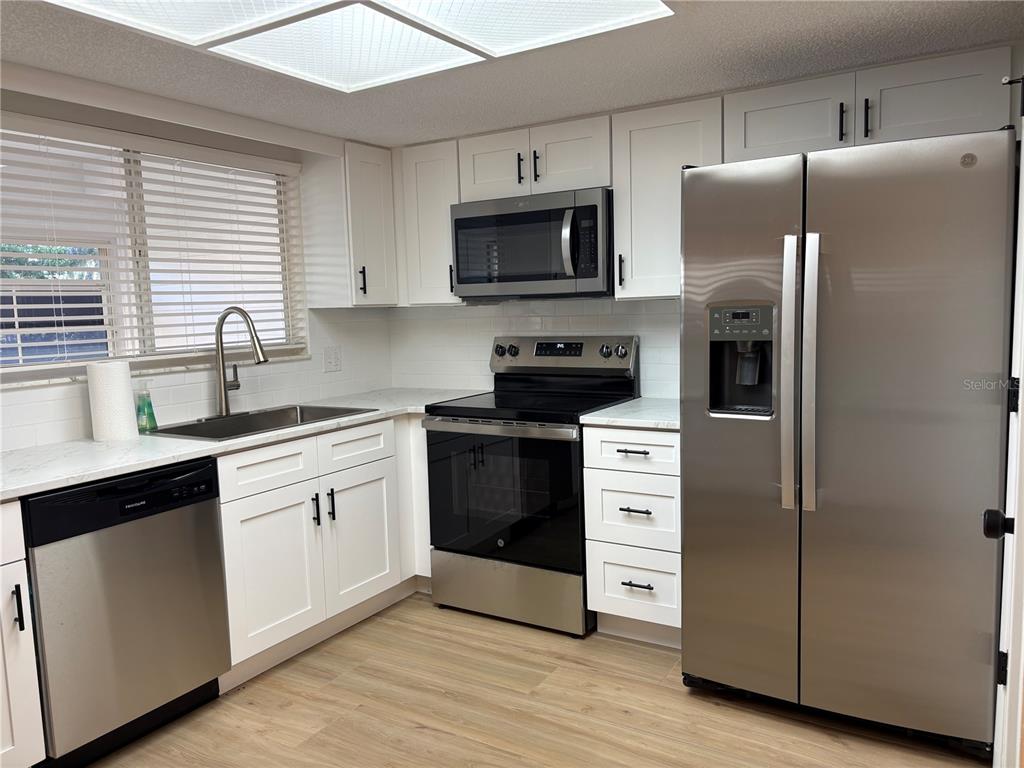 1455 Ridge Lake Court Lakeland, FL 33801 - Photo 5 of 15 a kitchen with stainless steel appliances a refrigerator stove and sink