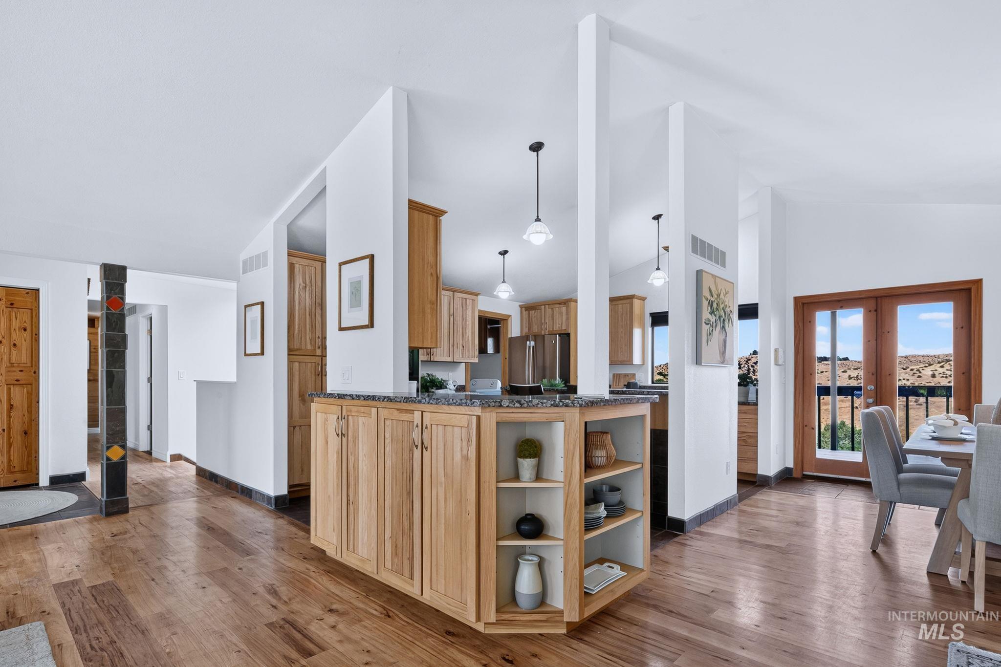 1750 East Shaw Mountain Road Boise, ID 83712 - Photo 11 of 47 Open-concept living area featuring wood-finish flooring and a kitchen island with granite-style countertops and built-in shelving