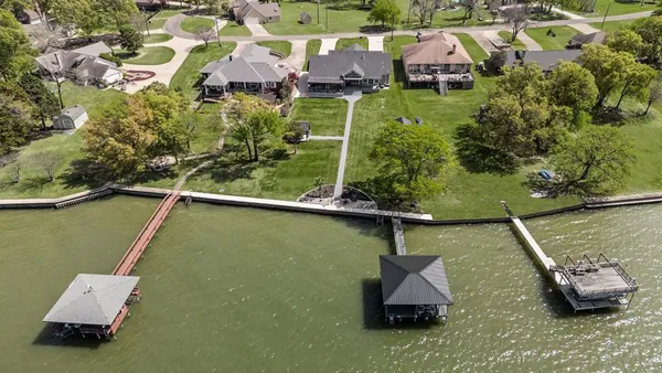 an aerial view of a house with swimming pool and lake view