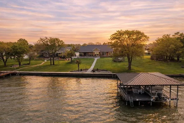 a view of a lake with a yard and furniture