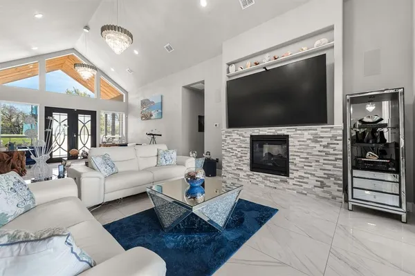 a living room with furniture a flat screen tv and a fireplace