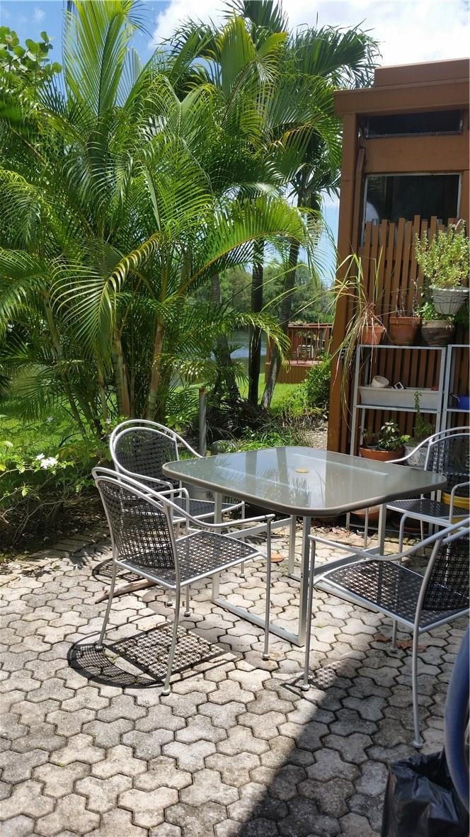 9711 North New River Canal Road, Unit 212 Plantation, FL 33324 - Photo 36 of 41 a backyard of a house with table and chairs
