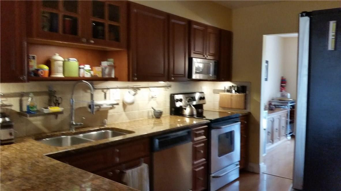 9711 North New River Canal Road, Unit 212 Plantation, FL 33324 - Photo 6 of 41 a kitchen with granite countertop a sink stove and cabinets