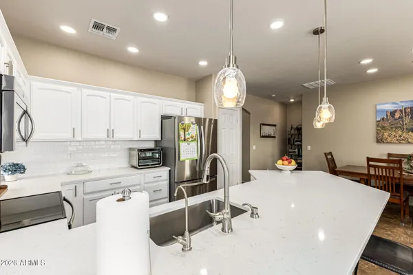 a large kitchen with kitchen island a large counter space a sink appliances and cabinets