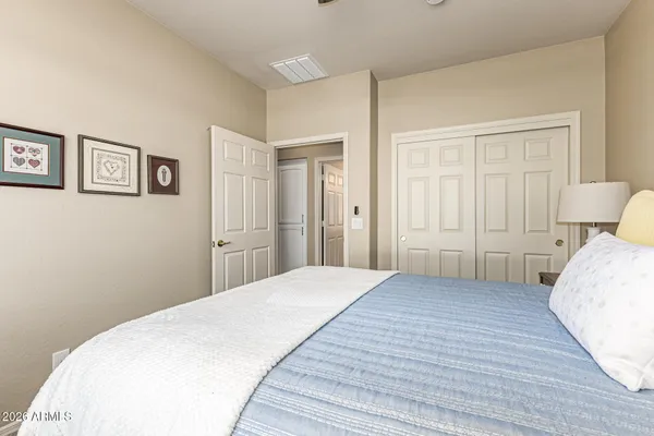 a bedroom with a bed and painting on the wall