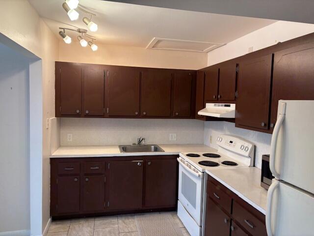 35 Mansfield A, Unit 35 Boca Raton, FL 33434 - Photo 2 of 17 a kitchen with kitchen island a stove a sink and a refrigerator with wooden cabinets