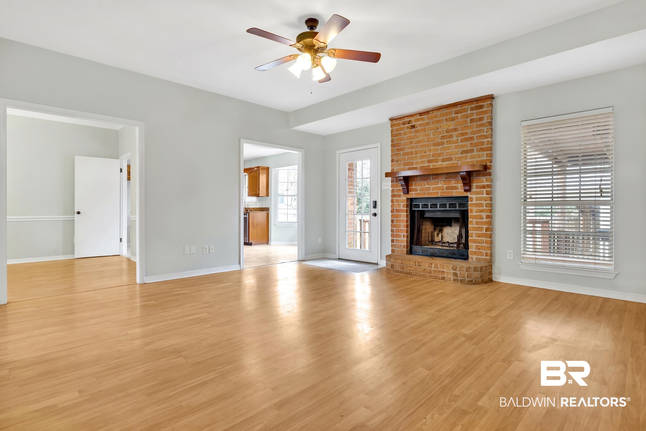 6616 Conde Court Mobile, AL 36695 - Photo 7 of 27 Unfurnished living room with light wood-type flooring, baseboards, ceiling fan, and a fireplace