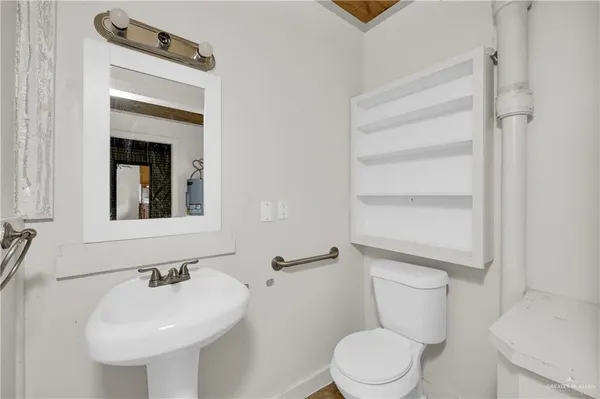 a bathroom with a toilet sink and mirror