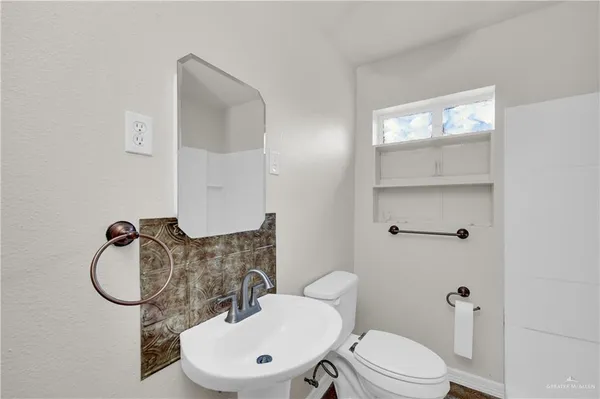 a bathroom with a toilet a sink and mirror
