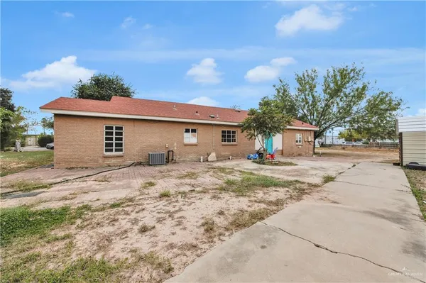 a view of a house with backyard space and a tree