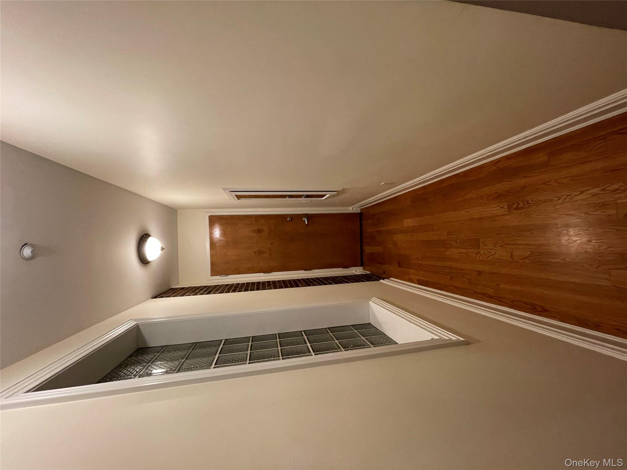 377 New York Avenue, Unit C Huntington, NY 11743 - Photo 1 of 10 a view of a hallway with wooden floor and staircase