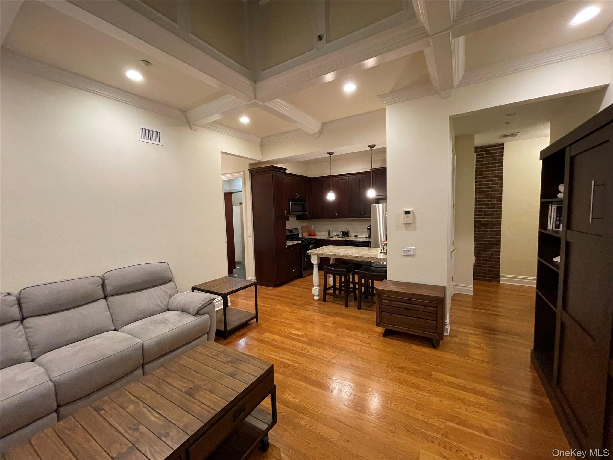 377 New York Avenue, Unit C Huntington, NY 11743 - Photo 4 of 10 a living room with furniture a piano and a flat screen tv