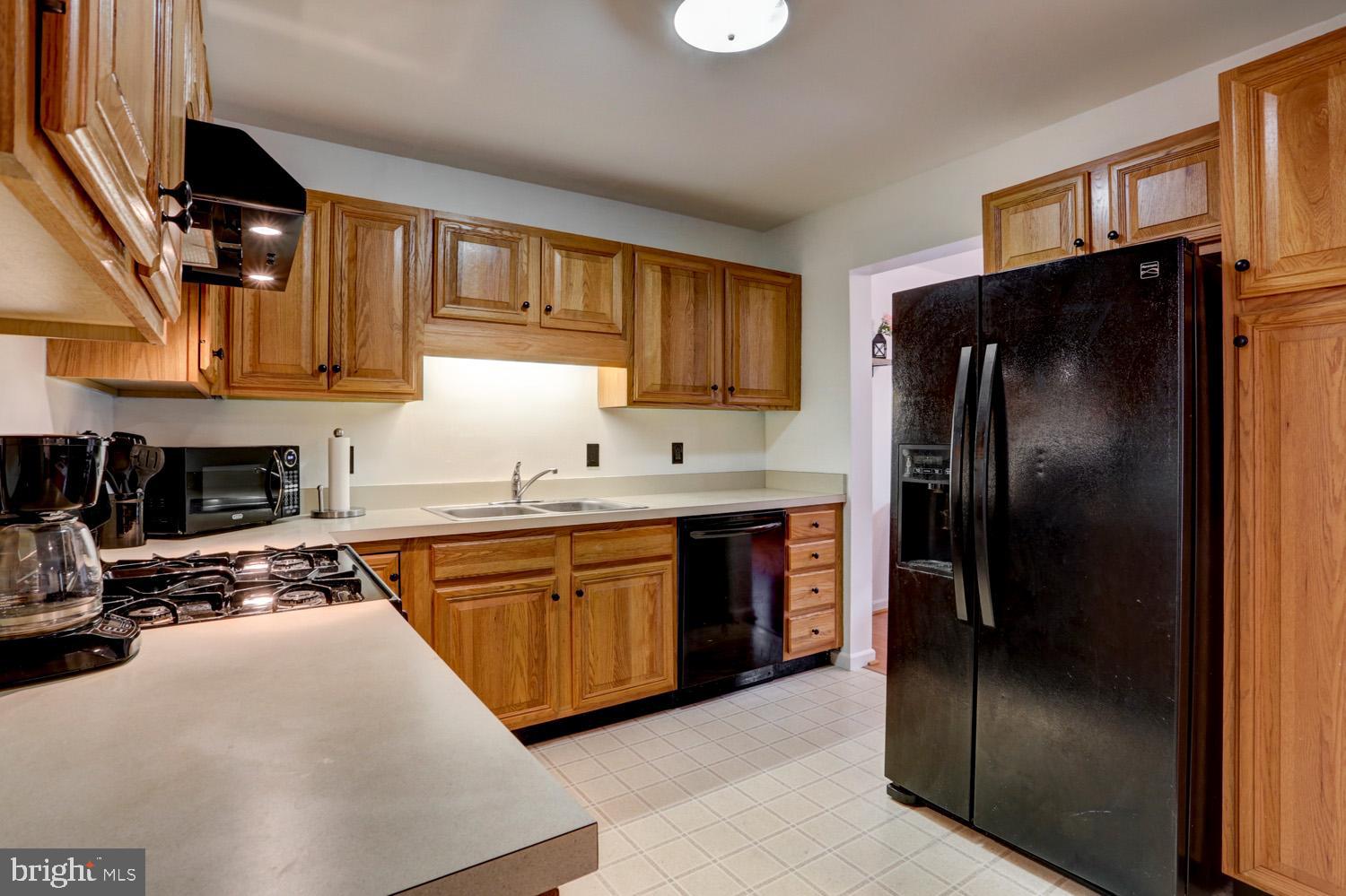 358 Crosswinds Drive Lititz, PA 17543 - Photo 15 of 39 a kitchen with stainless steel appliances granite countertop a refrigerator a stove and a sink with wooden cabinets