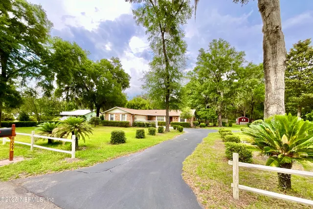 a view of a swimming pool with a bench and trees around
