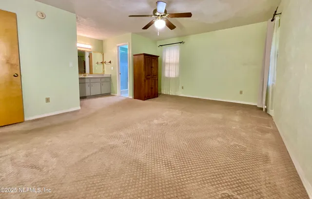a view of a big room with closet and a chandelier fan