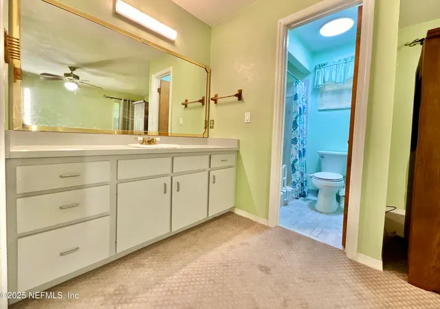 a spacious bathroom with a granite countertop sink a mirror and a shower