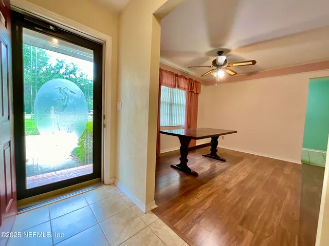 a view of a livingroom with a piano and wooden floor