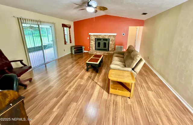 a view of a living room with furniture and a fireplace