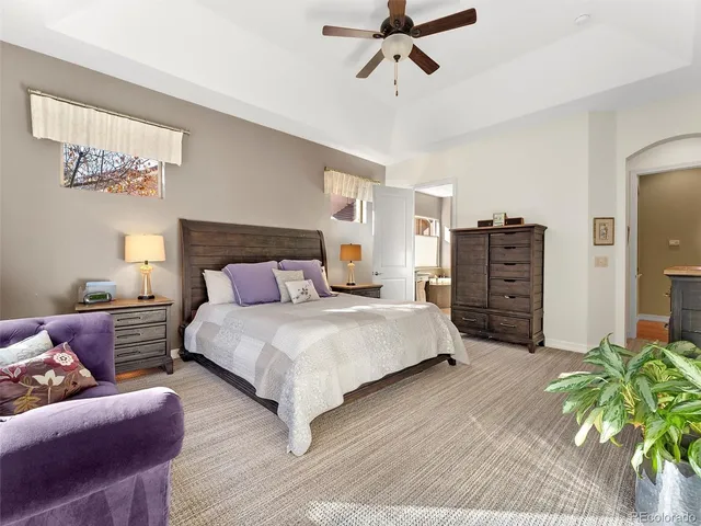 a spacious bedroom with a bed a dresser and flowerpot