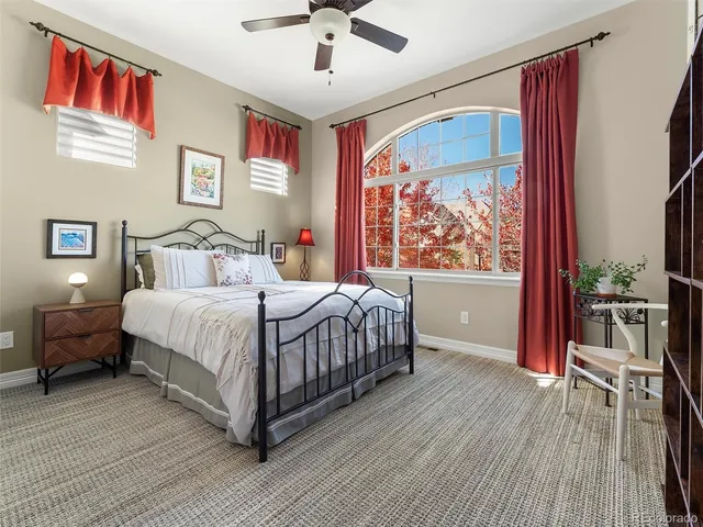 a bedroom with a large bed a chandelier and a window
