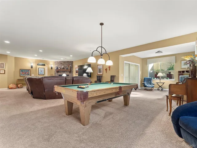 a room with pool table and chairs