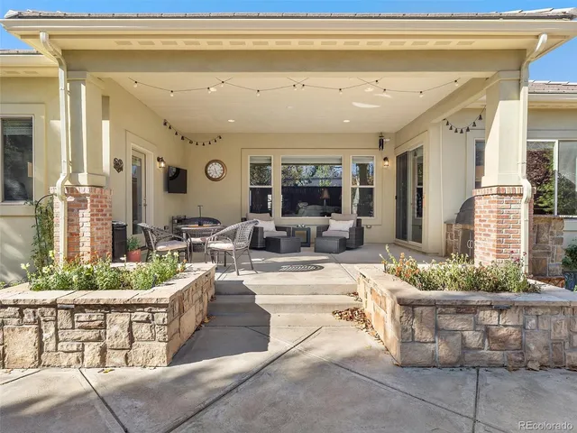 a view of a patio with couches table and chairs and potted plants