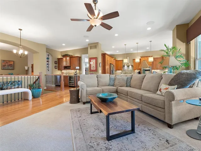 a living room with furniture and a large window with kitchen view
