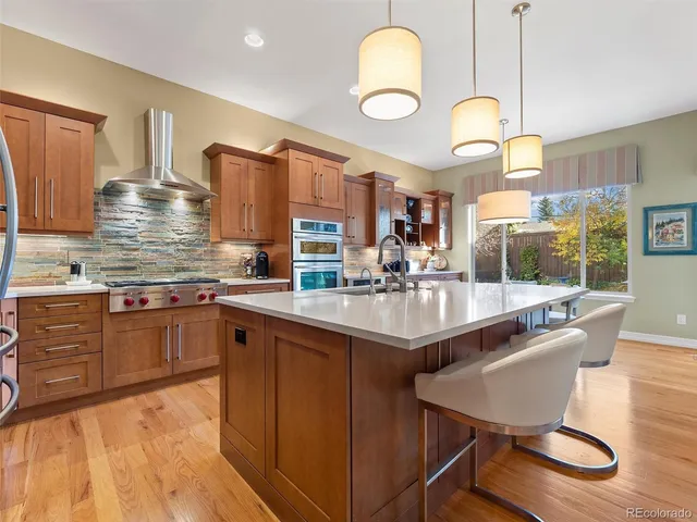 a kitchen with stainless steel appliances granite countertop a sink and wooden cabinets