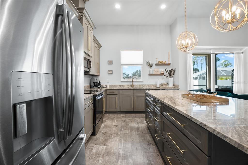 4528 Libby Road North Port, FL 34287 - Photo 17 of 43 a kitchen with granite countertop stainless steel appliances a sink stove and refrigerator