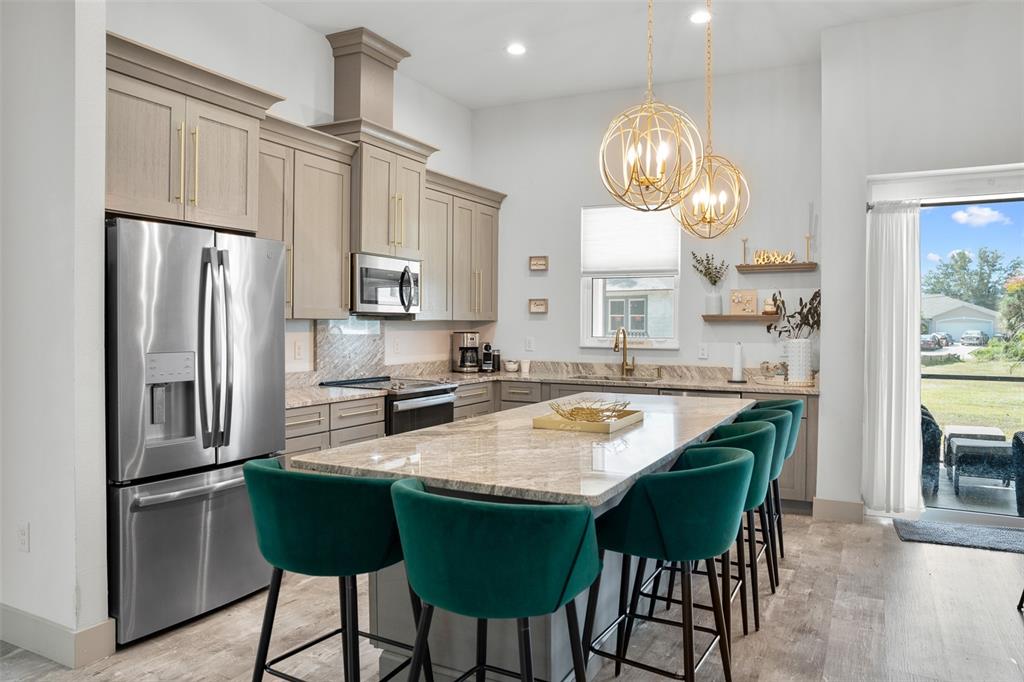 4528 Libby Road North Port, FL 34287 - Photo 19 of 43 a kitchen with stainless steel appliances granite countertop a stove a refrigerator a kitchen island a table and chairs