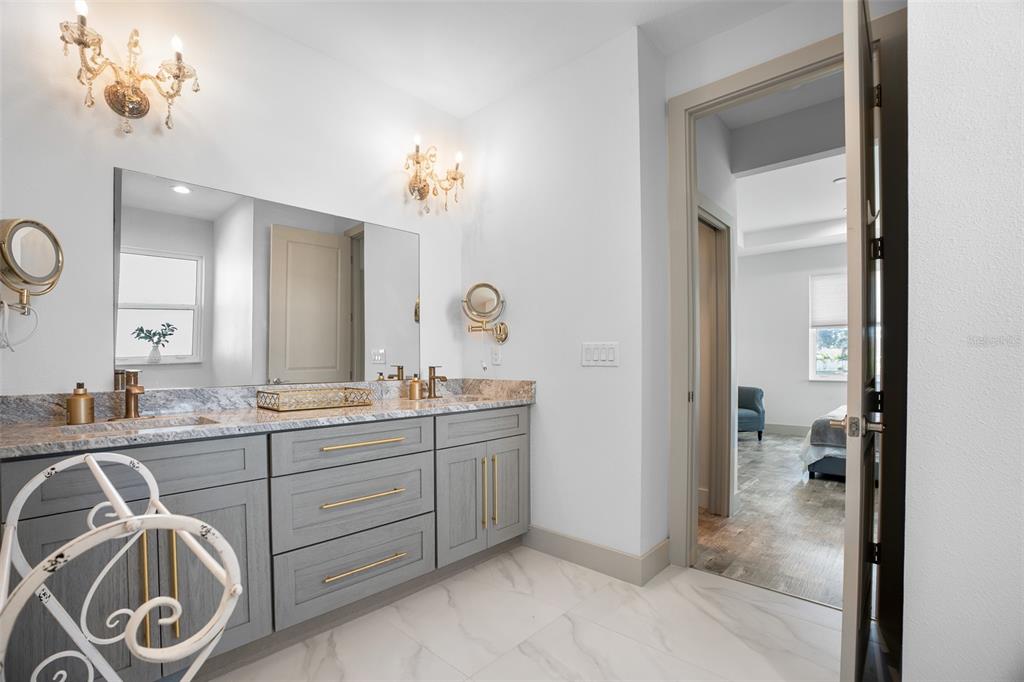 4528 Libby Road North Port, FL 34287 - Photo 25 of 43 a spacious bathroom with a granite countertop sink a mirror and a