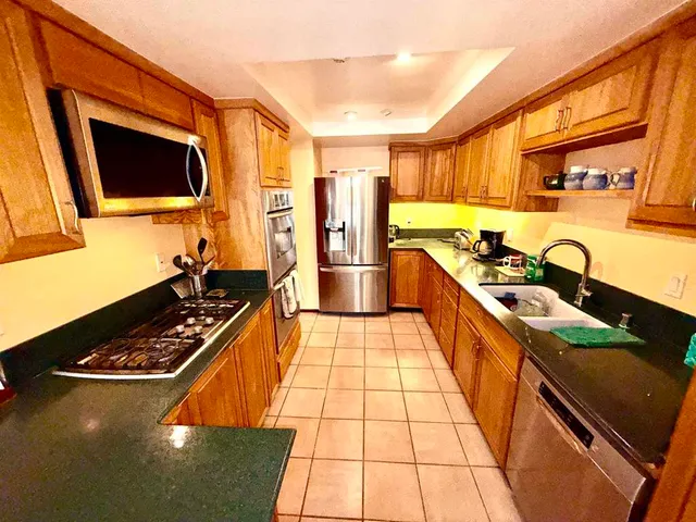 a kitchen with stainless steel appliances a stove a sink and a microwave