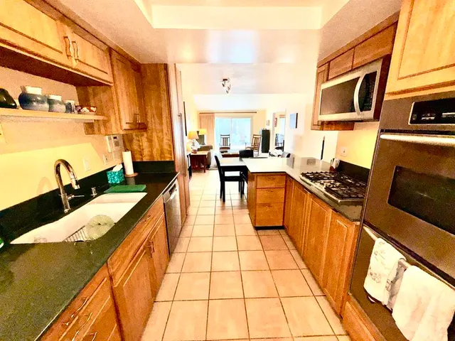 a large kitchen with stainless steel appliances a stove a sink dishwasher and cabinets