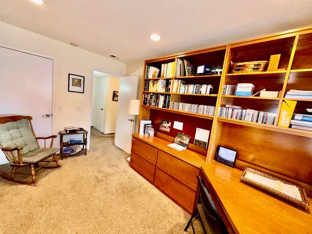 a living room with furniture and a book shelf
