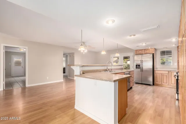 a kitchen with kitchen island a sink a stove a refrigerator and a stove