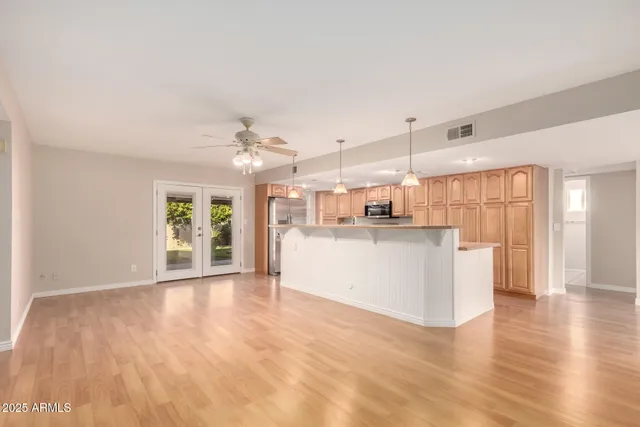 a view of a kitchen with wooden floor and windows