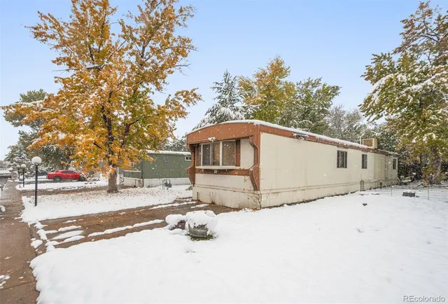 a front view of a house with a yard covered in snow
