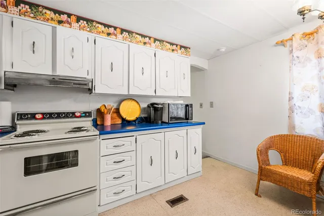 a kitchen with stainless steel appliances granite countertop a white stove top oven and white cabinets