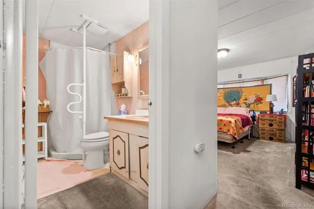 a bathroom with a granite countertop sink a toilet a mirror and shower