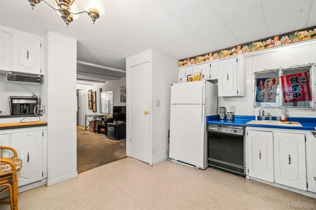a kitchen with refrigerator and cabinets