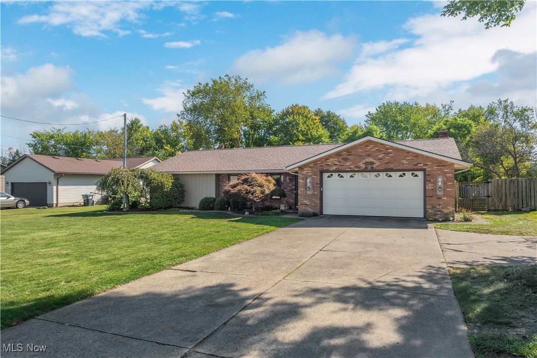 Single story home with a front yard and a garage