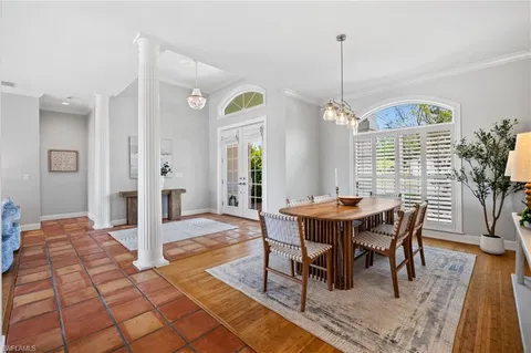 a dining room with furniture a chandelier and wooden floor