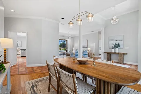 a dining room with stainless steel appliances a table and chairs