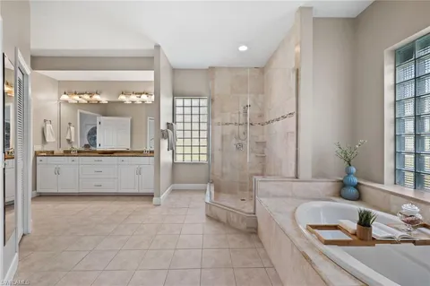 a bathroom with a tub a sink and a large mirror