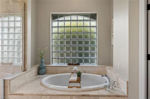 a bathroom with a granite countertop a sink and bathtub